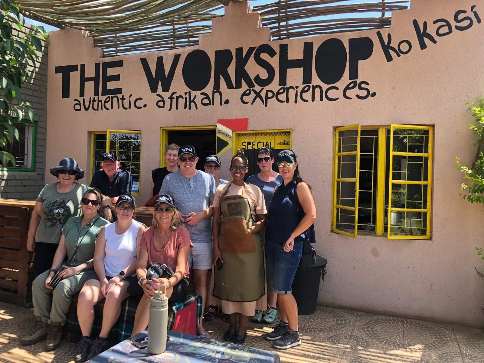 Group of Viva travellers posing outside Ko Kasi Workshop, a local community experience in South Africa.