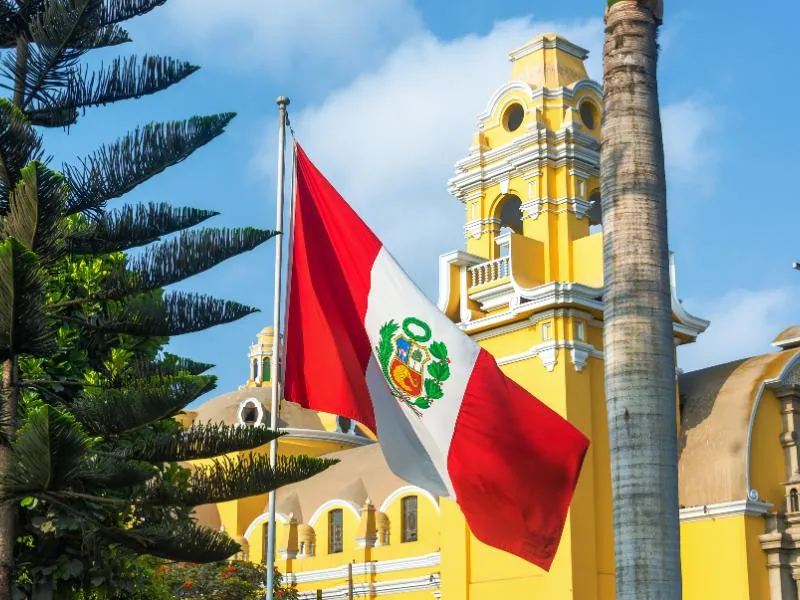 Peruvian flag and yellow church in Lima, Peru.