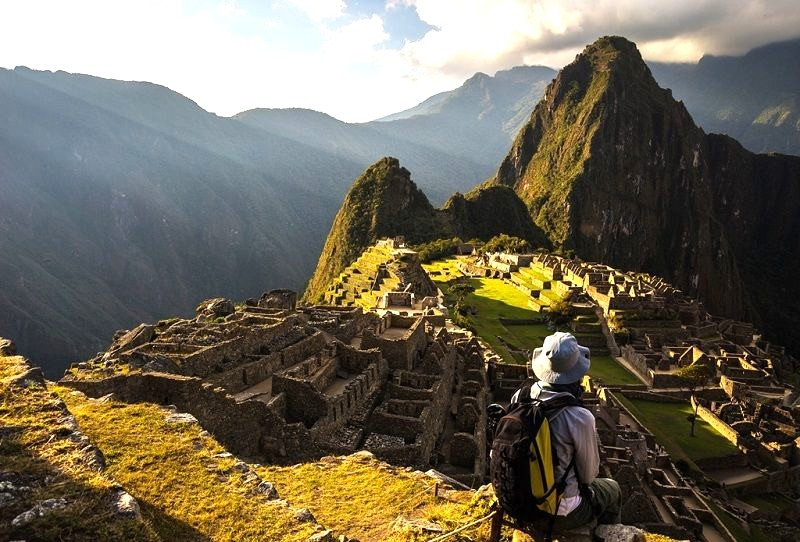 Hiker resting in front of the scenic Machu Picchu.
